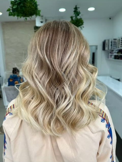 Blond auriu în lumina naturală a salonului, lângă plante