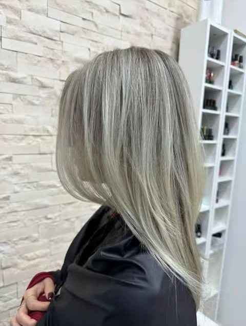 Blond argintiu neted, lângă rafturile cu oje ale salonului